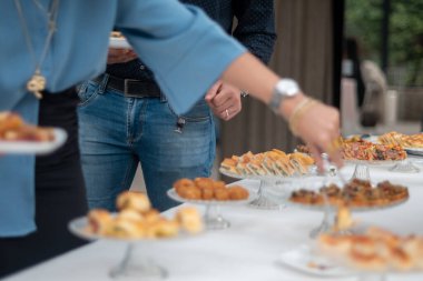 Elegant guests enjoy a delightful gourmet buffet at a sophisticated private event showcasing a variety of delicious appetizers and savory treats beautifully arranged for a memorable culinary