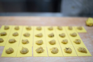 Lezzetli dolgu malzemeleriyle doldurulmuş taze el yapımı makarna karelerini kapatın.