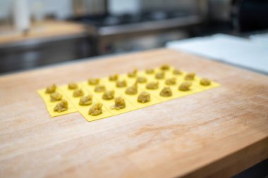 Yeşil İçindekilerle dolu taze hazırlanmış sarı hamur safları açık sarı plastik bir Mat 'a yerleştirilmiştir.