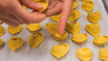 Artisan hands carefully craft fresh pumpkin stuffed ravioli pasta dough in a professional kitchen preparing seasonal Italian cuisine with meticulous attention to detail