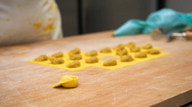 Passionate Chef Meticulously Prepares Delicate Vegetarian Stuffed Tortellini with Autumnal Fillings in a Bustling Small Business Kitchen Capturing Intricate Culinary Craftsmanship