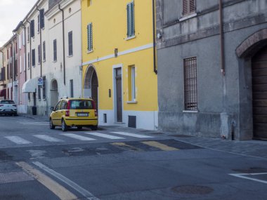 Canneto Konsolosu Oglio, İtalya 22 Eylül 2025 Vibrant sarı Fiat Panda 169 2003 'ten kalma büyüleyici bir Avrupa caddesine oturmuş yaya geçidi işaretleriyle süslenmiş ve çevresi pitoresk tarihi işaretlerle çevrili.