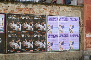 Cremona, Italy September 30th 2025 Multiple identical festival posters pasted on weathered brick and concrete wall in Lodi, Italy urban cultural event announcements