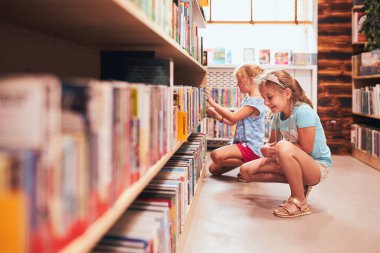 Okul kütüphanesinde kitap seçen iki kız öğrenci. İlkokul öğrencileri kitaplardan öğreniyor. Çocuklar okul kulübünde eğleniyor. Okula dönelim. Ödev yapıyorum.