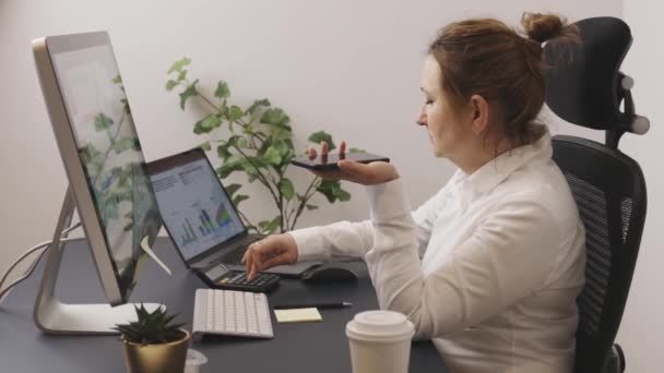有生意的女商人打电话到电脑上工作 企业家使用计算机和智能手机上的图表数据工作 远程工作的妇女 — 图库视频影像