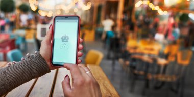 Al kullanıcı ile konuşan robot sohbet. Yapay zeka sohbet teknolojisini kullanarak. Yapay zeka uygulamalı akıllı telefon. Yapay Zeka ile konuşma. İletişim için yeni bir yol. Telefon ekranında robot simgesi. Yapay Zeka sohbet robotuna götüren kadın