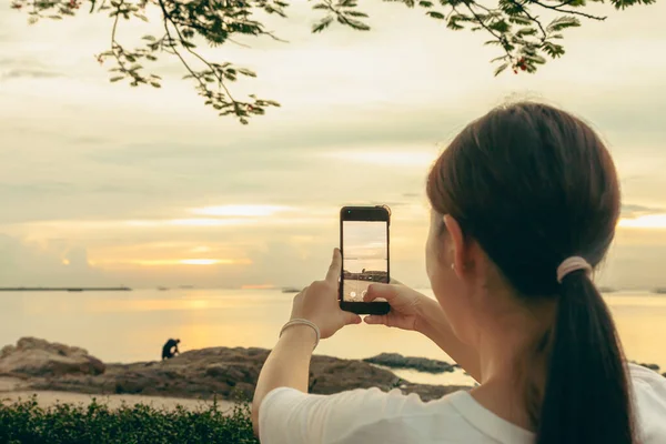 Asyalı kadınlar, sabah deniz ve sahilde cep telefonlarıyla fotoğraf ve video görüşmeleri yapıyorlar. Tatildeyken internete yüklemek için akıllı telefonlar kullanıyorlar..