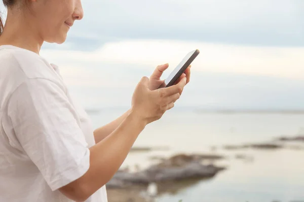 Asyalı kadınlar, sabah deniz ve sahilde cep telefonlarıyla fotoğraf ve video görüşmeleri yapıyorlar. Tatildeyken internete yüklemek için akıllı telefonlar kullanıyorlar..