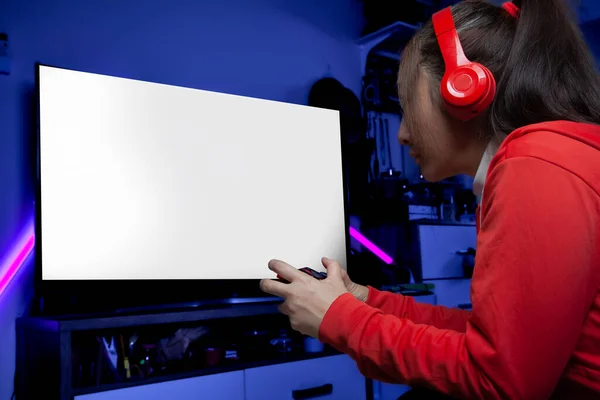 Kulaklıklı heyecanlı Asyalı kadın oyuncu elinde joystick ile online video oyunu oynuyor. Profesyonel flamalar kırmızı giysiler içinde oyun oynuyorlar sosyal oyun oynarken eğleniyorlar. Siber Neon Işıkları Biçimi