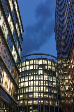 Hamburg, Almanya - 25 Ocak 2012: Modern Hamburg şehri. Hamburg 'un HafenSity semtindeki ofis manzaralı gece sahnesi.