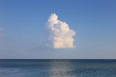 Deniz manzarası üzerinde yalnız bulutlar. Yükselen kümülüs bulutu yaz günü.