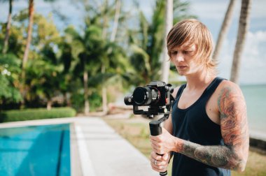 Kameraman dışarıda kamerasıyla ve vibratörüyle dikiliyor. Seçici odak