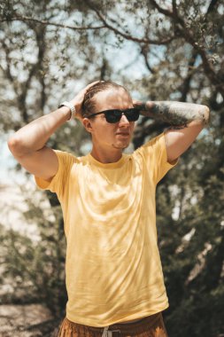 Kumsalda duran at kuyruklu sarışın adam. Yüksek kalite fotoğraf