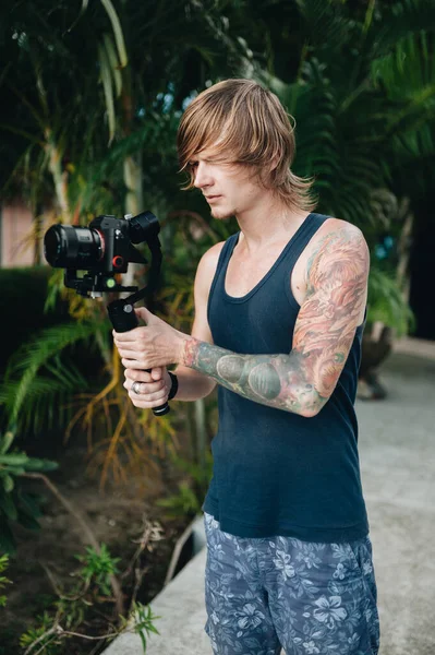 男のビデオカメラマンはカメラとジンバルで屋外に立っている 選択的焦点 — ストック写真