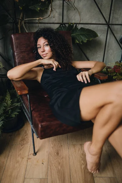 Retrato Uma Mulher Encaracolada Sorridente Sentada Uma Cadeira Foto Alta — Fotografia de Stock