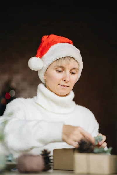 Perempuan Santa Hat Wrapping Natal Menyajikan Dengan Bahan Eko Rumah — Stok Foto