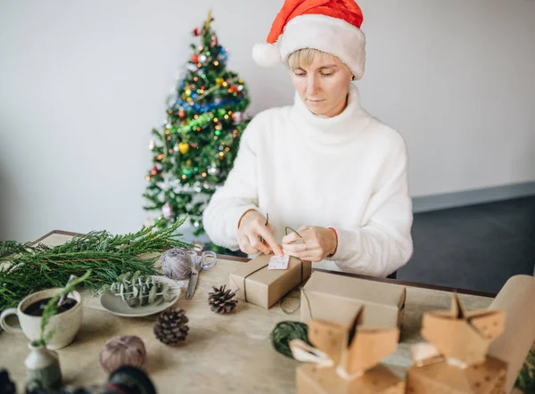Perempuan Santa Hat Wrapping Natal Menyajikan Dengan Bahan Eko Rumah Stok Lukisan  
