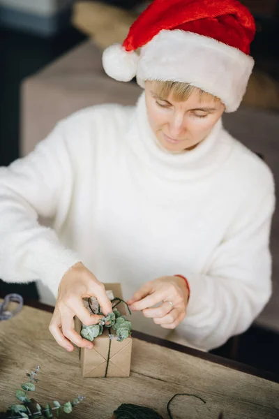 Perempuan Santa Hat Wrapping Natal Menyajikan Dengan Bahan Eko Rumah Stok Foto Bebas Royalti