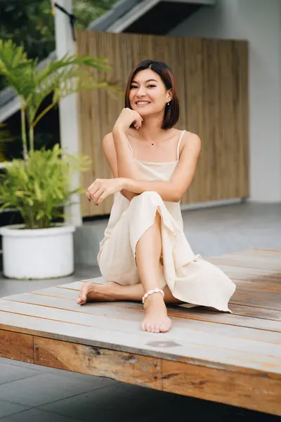 Aantrekkelijke Aziatische Vrouw Een Beige Jurk Zit Buiten Hoge Kwaliteit Stockfoto