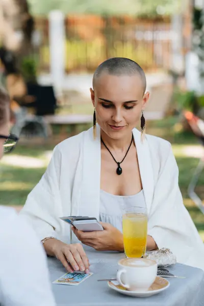 A bald woman tarot reader has a session with a client. High quality photo
