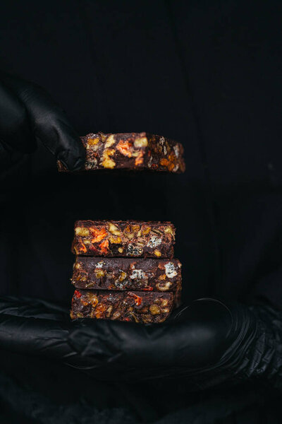 Hands Black Gloves Holding Chocolate Bars Mixed Nuts Fruits Black Royalty Free Stock Photos