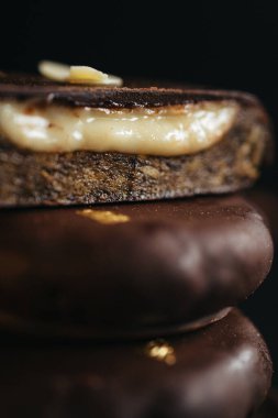 Çikolatadan, kurutulmuş meyvelerden ve koyu arkaplanda hindistan cevizi kremasından yapılmış bir tatlı. Yüksek kalite fotoğraf