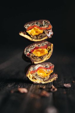 Kurumuş meyvelerden yapılmış, koyu arkaplanda koyu çikolatalı şekerlerle dolu sakin bir hayat. Yüksek kalite fotoğraf