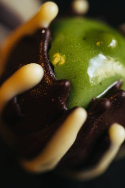Siyah arka planda içinde yeşil şam fıstığı olan iki çikolata şekeri. Yüksek kalite fotoğraf
