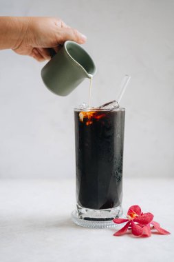 Beyaz mermer arka planda, masada sütlü buzlu Americano.