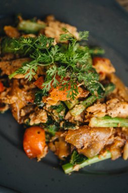 Tahta masada tavuklu ve sebzeli bir tabak Tayland usulü şehriye.