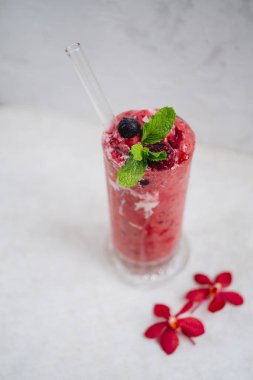 Beyaz arka planda yoğurtlu yabanmersini smoothie.