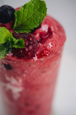 Beyaz arka planda yoğurtlu yabanmersini smoothie.