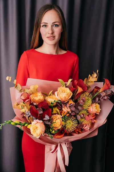 抱着橙色秋天五彩缤纷的秋天花束的女人 盛开的花朵 喜庆的背景 秋天的橘红色花朵 花束花卡 母亲节 国际妇女日 — 图库照片