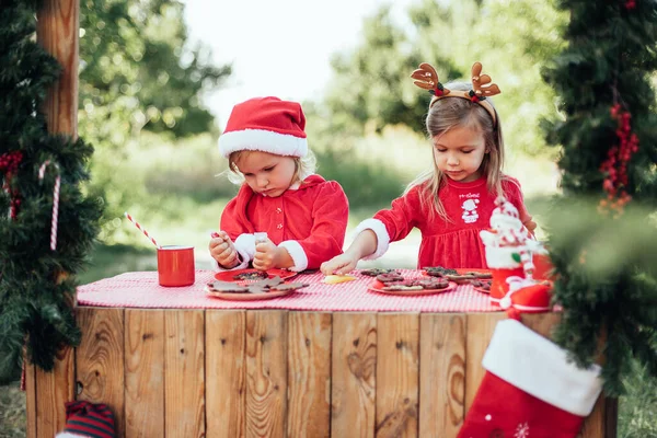 Happy Children Preparing Christmas Two Girls Santa Hat Coloring Gingerbread — Stockfoto
