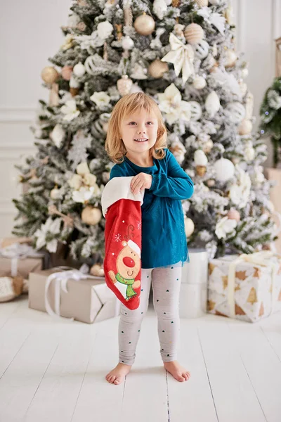 Happy excited girl child holding christmas gift box. Happy little girl excited at Christmas Eve. Hope concept Waiting for Santa claus. Hopeful child. New year eve. Dreams come true.
