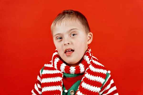 快乐儿童与唐氏综合征在圣诞围巾有乐趣和笑在工作室 圣诞气氛 新年快乐 红色背景的肖像 — 图库照片