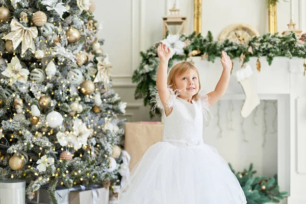 Happy excited girl child dancing near Christmas tree. Happy little girl excited at Christmas Eve. Hope concept Waiting for Santa claus. Hopeful child. New year eve. Dreams come true.