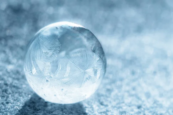stock image frozen bubble with bokeh background. Beautiful frosty patterns on frozen soap bubble. winter, frosty background. Macro photo