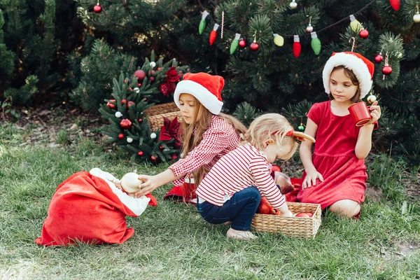 メリークリスマス サンタの帽子の3人の面白い子供たちの肖像は 楽しさを持って外でホットチョコレートを飲むジンジャーブレッドクッキーを食べています ハッピー ホリデー 休日を楽しむ子供たち 7月のクリスマス — ストック写真