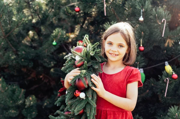 メリークリスマス クリスマスリースとサンタの帽子の幸せな面白い子供の女の子の肖像画 ハッピー ホリデー 妖精の魔法 幸せな子供は休日を楽しんでいる 7月のクリスマス — ストック写真
