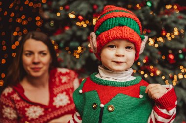 Noel ağacının altında mutlu bir aile. Noel Baba şapkalı bebek Noel ağacının altında hediyeler ve hediyeler. Mutlu tatiller, yeni yıl. Evde sıcak bir kış akşamı. Xmas zamanı.