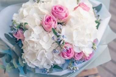 Çiçekler arka planda beyaz ortanca çiçekleri ve pembe güller. Doku, üst manzara, yakın çekim. Çiçekler açan, şenlikli arka plan, pastel ve yumuşak buket çiçekli kart.