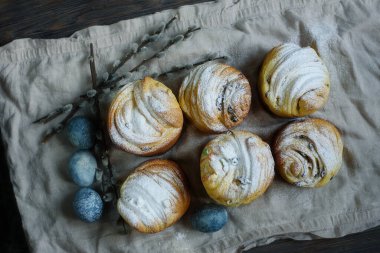 Geleneksel kek Paskalya pastası Kraffin. Koyu ahşap arka planda kuru üzümlü. Şekerli meyveli ev yapımı kek Cruffin. Doğal olarak mermer taşlı amber çiçeğiyle boyanmış yumurtalar..