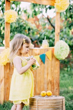 Çocuk kız parkta doğal limonata içiyor. Yaz ferahlatıcı doğal limonata. Detoks meyvesi aromalı su, içecek kutusunda taze meyveli kokteyl.
