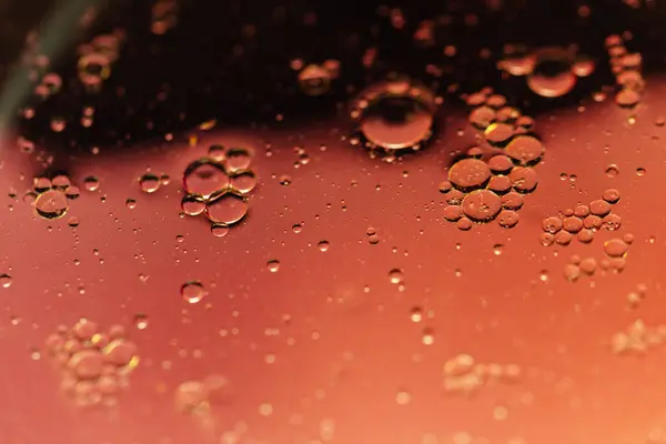 oil with bubbles on orange background. Abstract space background. Soft selective focus. macro of oil drops on water surface. copy space. air bubbles in water
