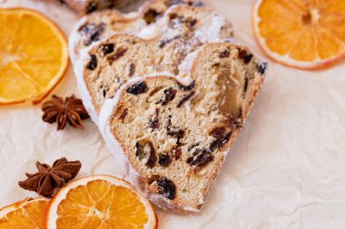 Ahşap arka planda Noel çalıntısı. Geleneksel yılbaşı Alman tatlıları parçalara ayrılmış. Fındıklı kek, badem ezmeli kuru üzüm ve kesme tahtasında kurutulmuş meyve. Xmas için pişirme