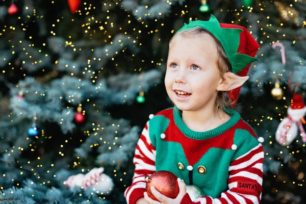 Christmas in July. children elf ears. Child waiting for Christmas in wood in july. portrait of little girl decorating Christmas tree. winter holidays and people concept. Happy Holidays.