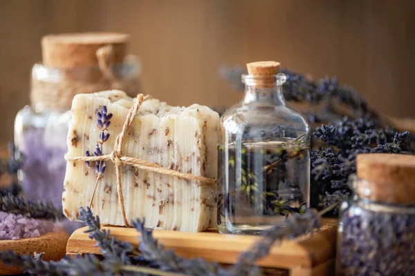 Wellness treatments with lavender flowers on wooden table. Spa still-life. Essential oils, sea salt and handmade soap. Natural herb cosmetic with lavender flowers