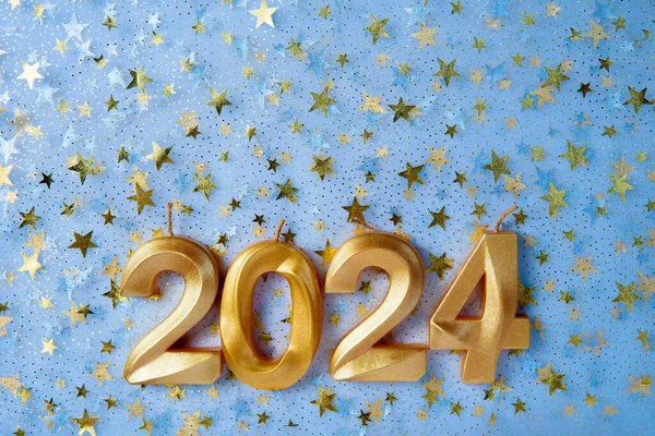 Holiday background Happy New Year 2024. Numbers of year 2024 made by gold candles on bokeh festive sparkling background. celebrating New Year holiday, close-up. Space for text