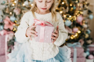 Mutlu Noeller ve mutlu tatiller. Noel ağacının altında küçük bir çocuk. Noel ağacının altında bir sürü hediye kutusuyla hediyeli küçük bir kız. Yeni Yıl Kutlaması.